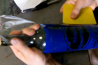 Aligning a sandblasting stencil on the wine bottle for etching.