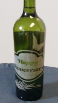 A sandblasted wine bottle with designs.
