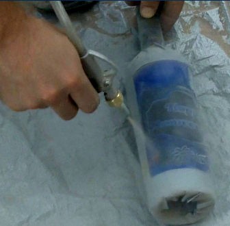 Sandblasting the wine bottle in action with a variable pressure pot nozzle.